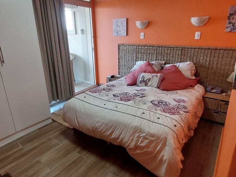 A bedroom featuring tiled flooring, a built-in wardrobe, and a sliding glass door providing access to an outdoor area.