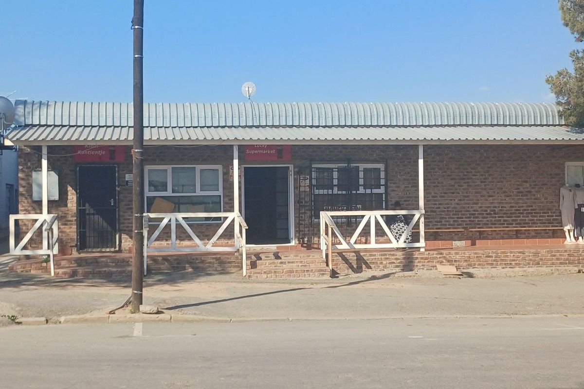Front view of a commercial building featuring a brick facade, covered veranda with timber railings, and secure entrance points.
