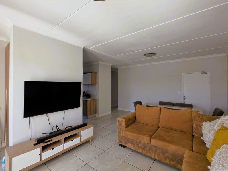 Open plan living and dining area featuring neutral tiled flooring and a clean, functional layout with direct access to the kitchen.