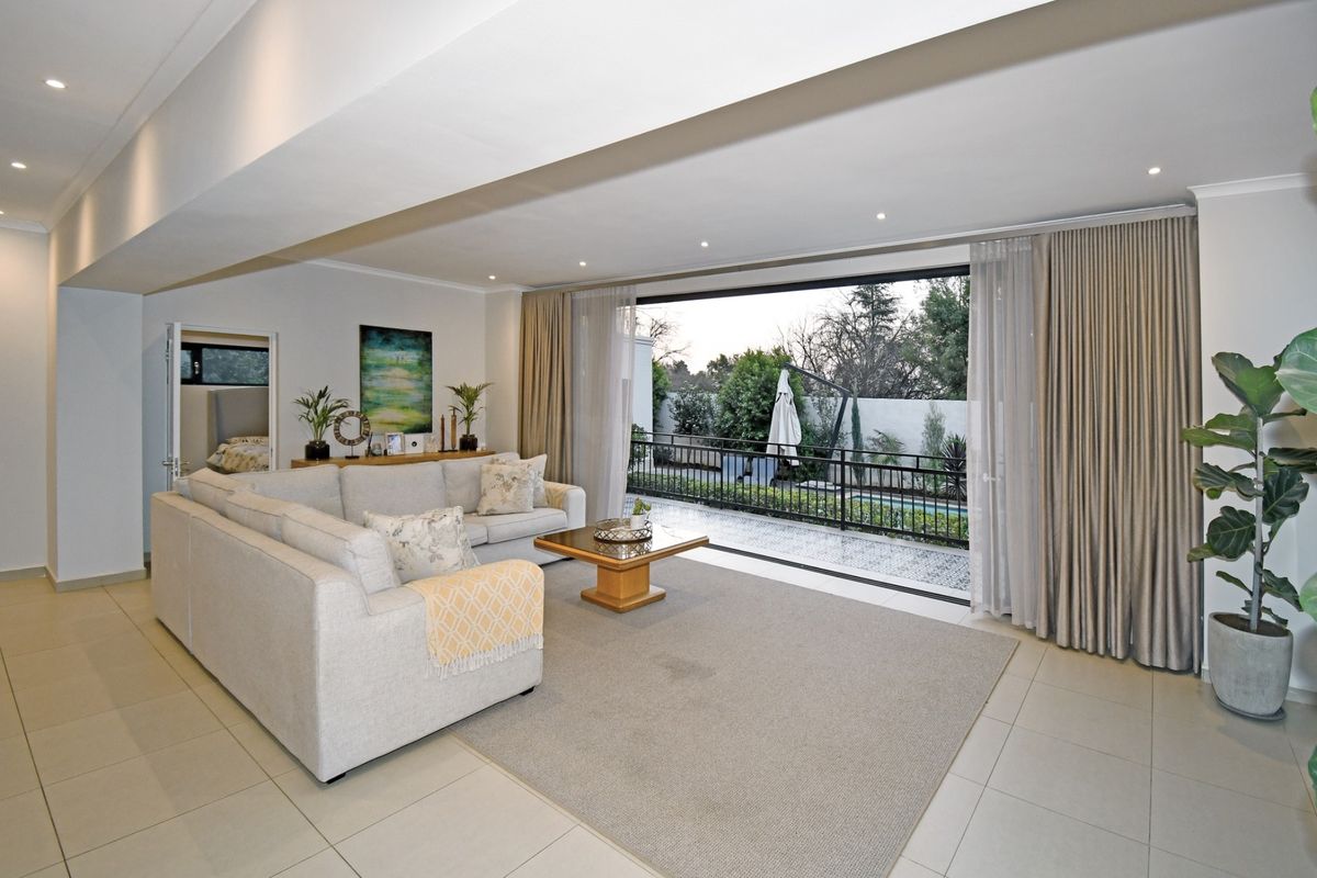 Spacious living room featuring large sliding glass doors that open onto a patio, providing seamless indoor-outdoor flow and abundant natural light.