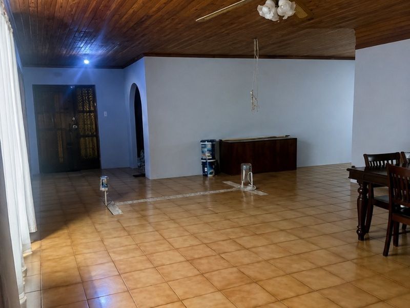 Spacious living area featuring a timber tongue and groove ceiling, ceiling fan, and ceramic tiled flooring with an open-plan layout.