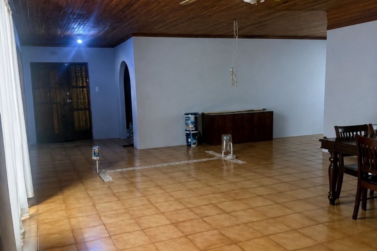 Spacious living area featuring a timber tongue and groove ceiling, ceiling fan, and ceramic tiled flooring with an open-plan layout.