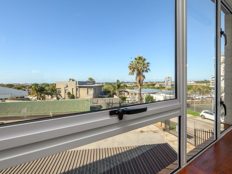 A clear view of the surrounding neighbourhood and landscape captured through a modern aluminium-framed window.