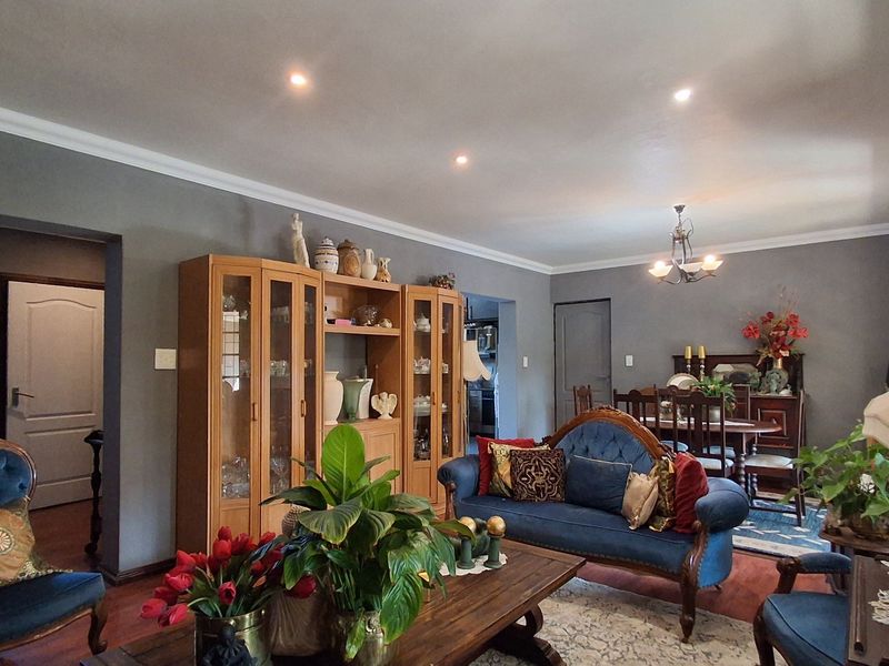 Spacious open-plan living and dining area featuring hardwood flooring, recessed downlighting, and decorative coving throughout the main living space.