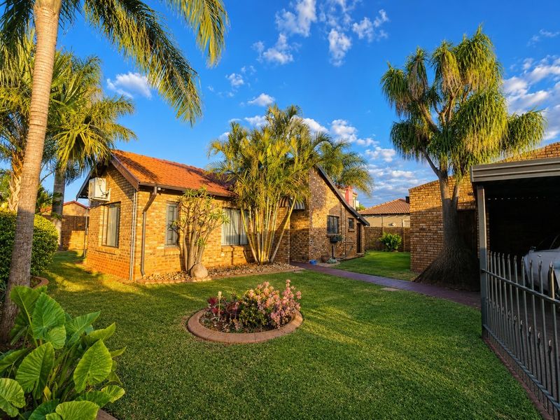 A well-maintained face brick house featuring a tiled roof, established garden, and paved walkway, showcasing classic architectural appeal and curb presence.