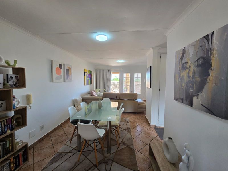 Open-plan living and dining area featuring tiled flooring, recessed lighting, and direct access to an outdoor patio space.