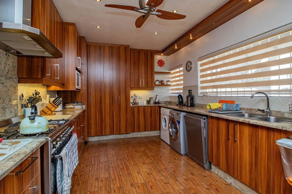 A well-appointed kitchen featuring wood-grain cabinetry, granite countertops, integrated appliances, and a gas stove, offering a functional and warm cooking space.