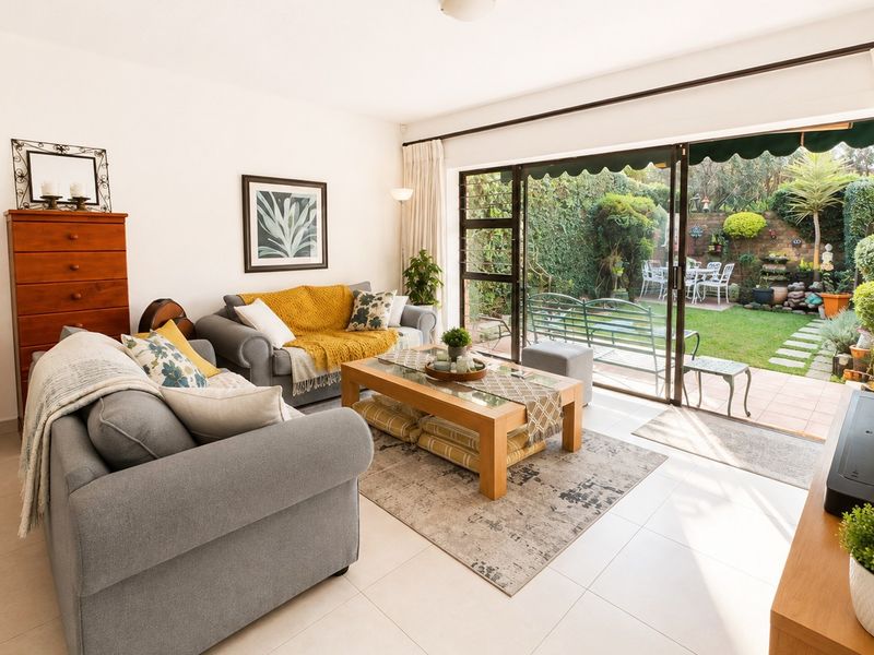 Bright living room featuring large sliding glass doors that provide seamless access to the rear patio and garden area.