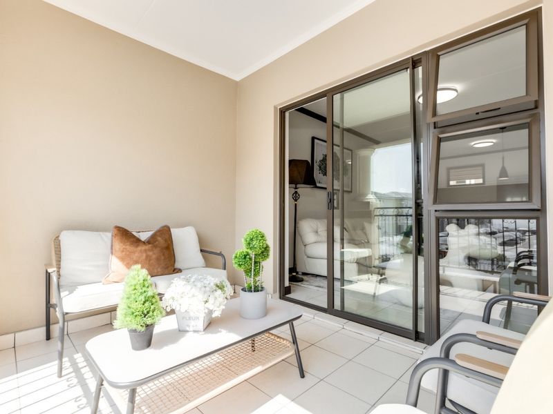 A covered balcony featuring tiled flooring and large sliding glass doors that provide seamless access to the interior living space.
