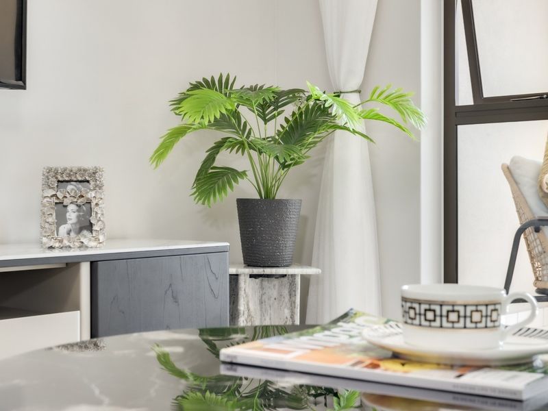 A close-up view of a modern living area featuring clean wall finishes and a dark aluminium window frame.