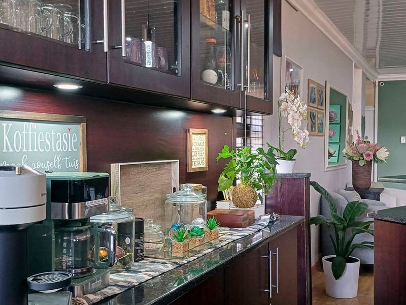 A well-maintained kitchen featuring dark wood cabinetry, granite countertops, and integrated under-cabinet lighting, creating a functional and stylish preparation area.