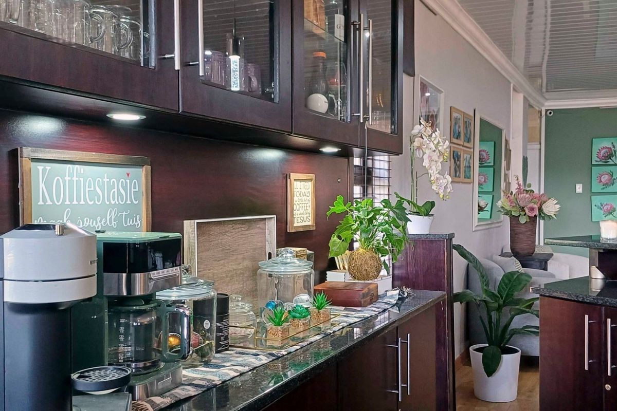A well-maintained kitchen featuring dark wood cabinetry, granite countertops, and integrated under-cabinet lighting, creating a functional and stylish preparation area.
