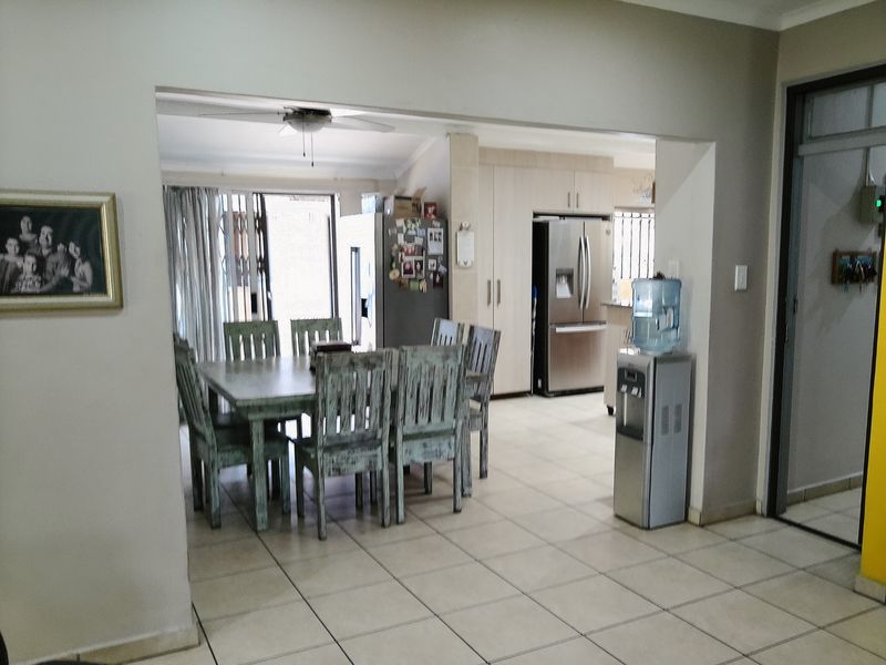 Open plan dining and kitchen area featuring tiled flooring, built-in cabinetry, and direct access to the outdoor space via a sliding glass door.