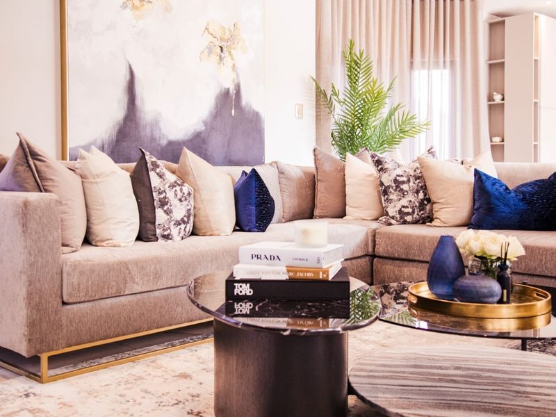 A well-appointed living room featuring neutral tones, elegant drapery, and integrated shelving, creating a sophisticated and comfortable atmosphere.
