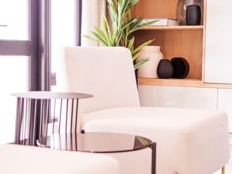 A bright living area featuring modern built-in timber shelving and large glass doors providing ample natural light.