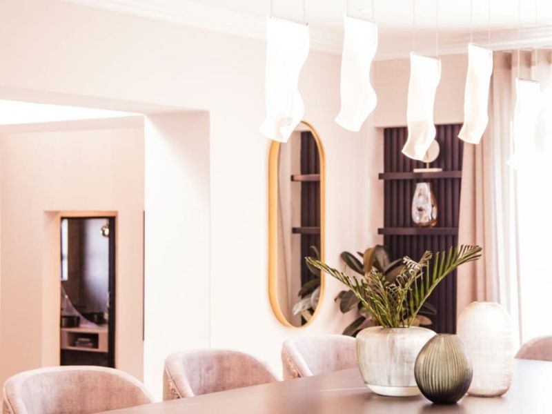 Elegant dining room featuring sophisticated pendant lighting, crown molding, and built-in shelving, creating a refined and well-appointed space for formal meals.