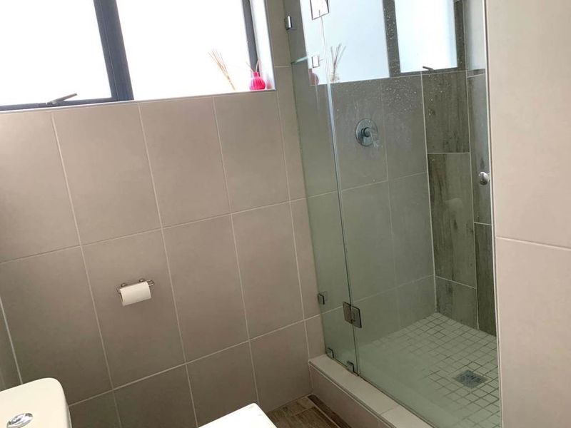 Modern bathroom featuring a glass-enclosed shower with neutral wall tiling and contemporary floor finishes.
