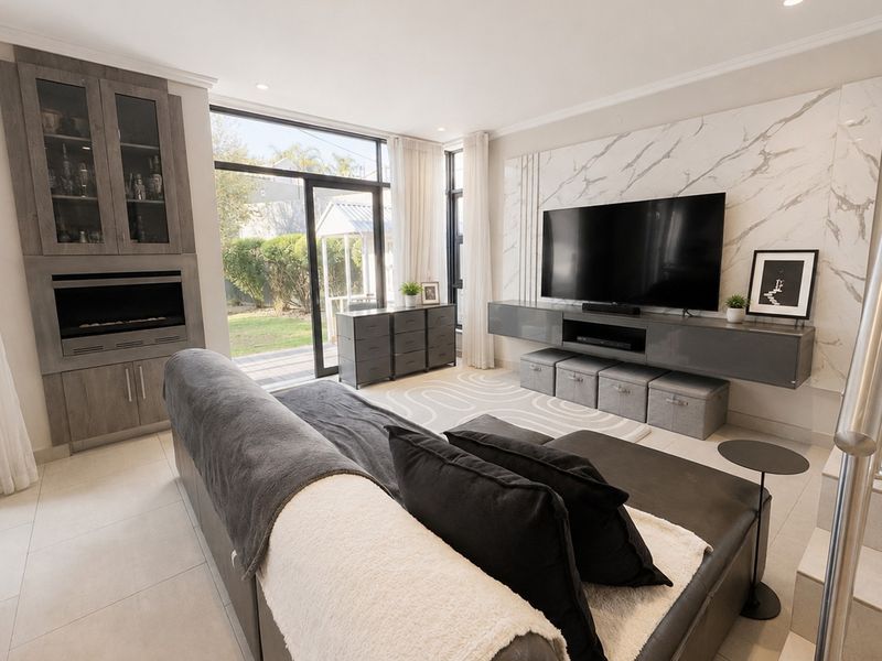 Modern living room featuring a marble-look feature wall, built-in cabinetry, and large sliding glass doors providing access to the rear garden.