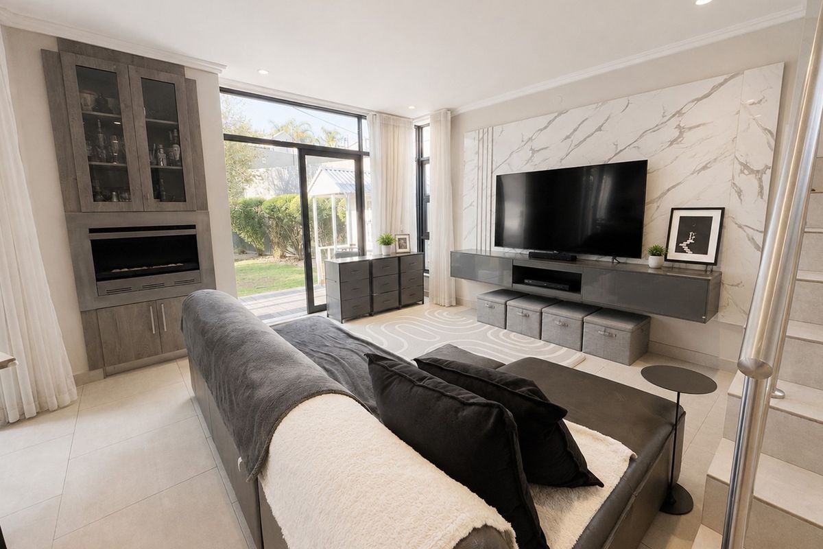 Modern living room featuring a marble-look feature wall, built-in cabinetry, and large sliding glass doors providing access to the rear garden.