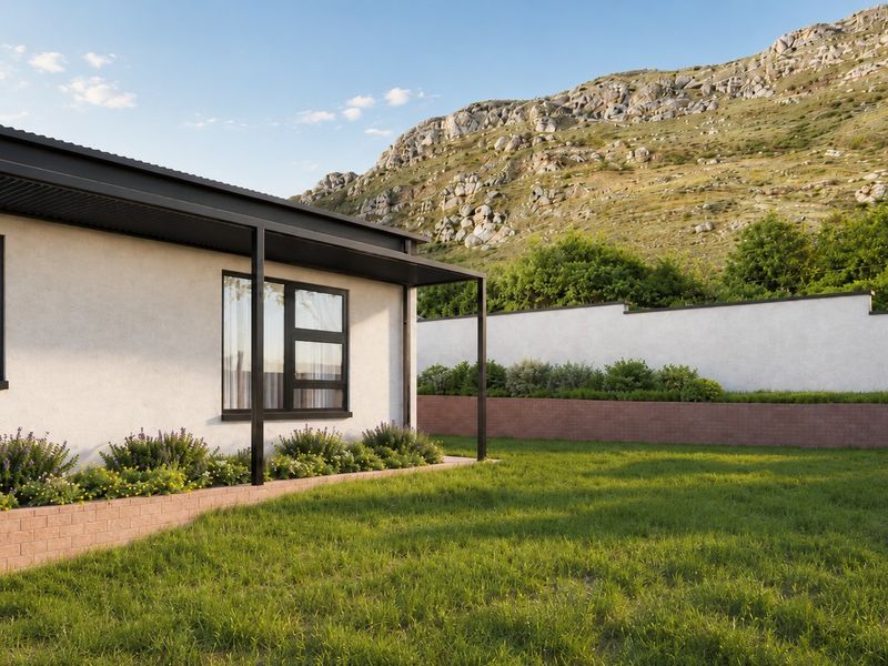 A well-maintained rear exterior view featuring a modern home facade, covered patio area, landscaped garden, and a scenic mountain backdrop.