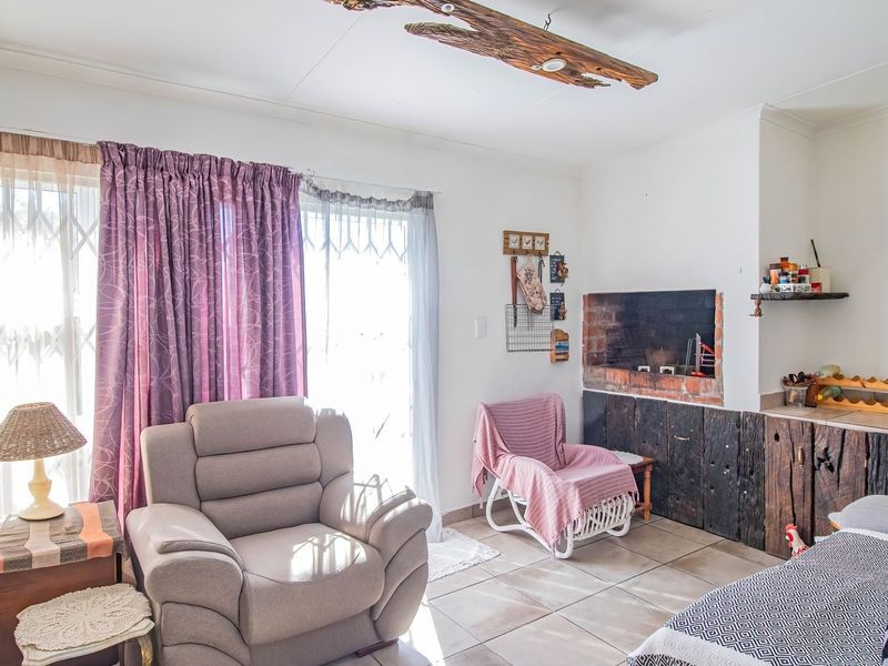 A living room featuring a built-in brick fireplace, tiled flooring, and sliding glass doors providing access to the exterior.