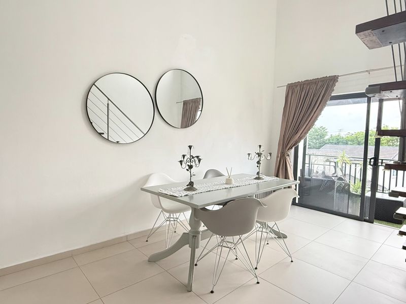 A bright dining area featuring neutral tiled flooring and a large sliding glass door providing access to an outdoor balcony.