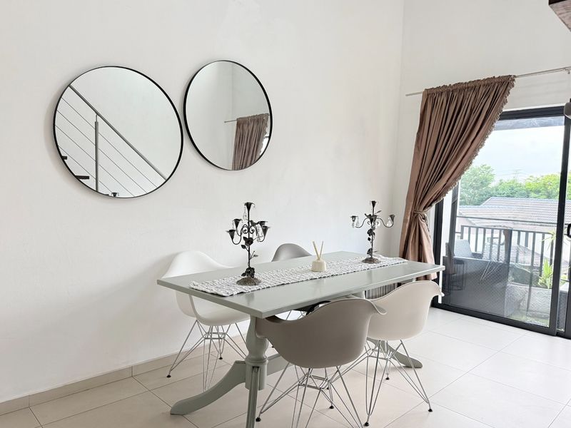 A bright dining area featuring neutral tiled flooring and a large sliding glass door providing access to an outdoor balcony.