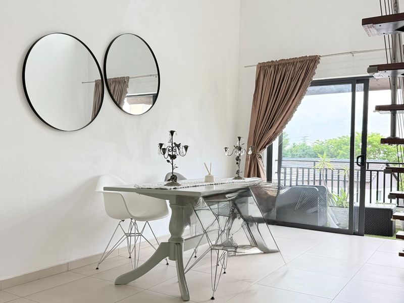 A bright dining area featuring tiled flooring, a staircase, and a large sliding glass door providing access to an outdoor balcony.