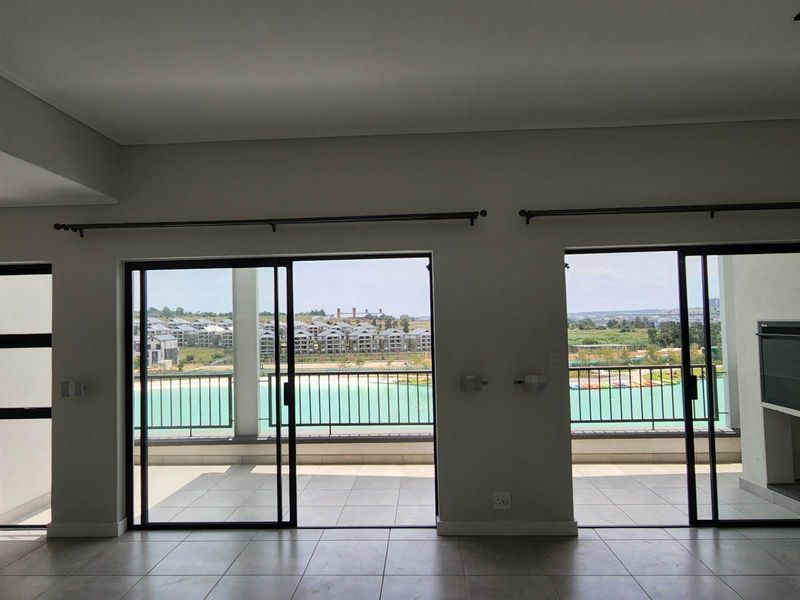 Spacious living area featuring large sliding glass doors that open onto a balcony with scenic views, providing ample natural light.