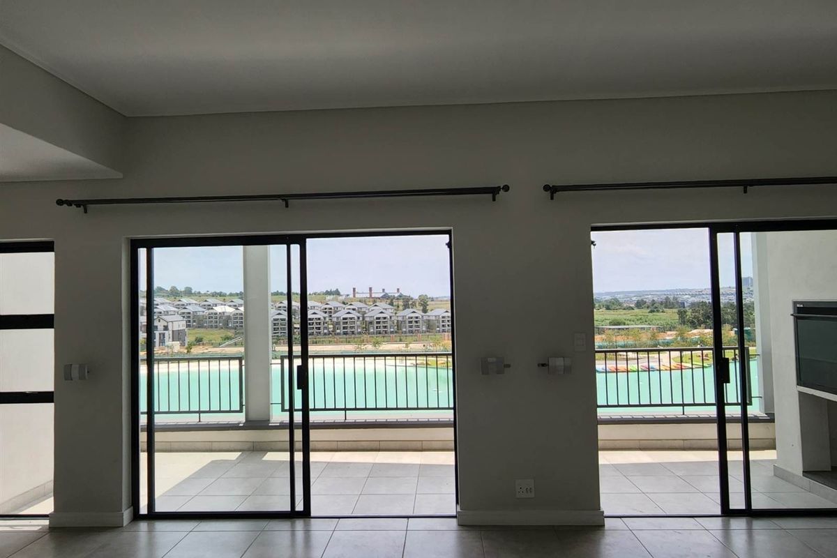 Spacious living area featuring large sliding glass doors that open onto a balcony with scenic views, providing ample natural light.