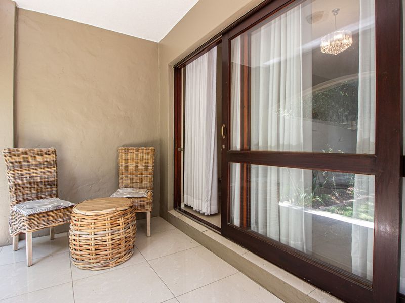 A covered patio area featuring tiled flooring and large sliding glass doors providing access to the interior living space.