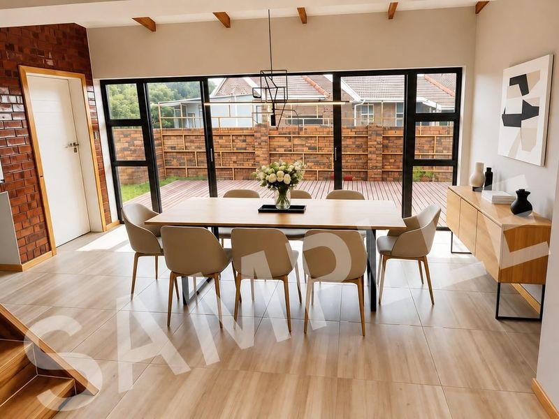 Modern dining room featuring exposed timber ceiling beams, a striking brick feature wall, and large sliding glass doors opening to an outdoor deck.