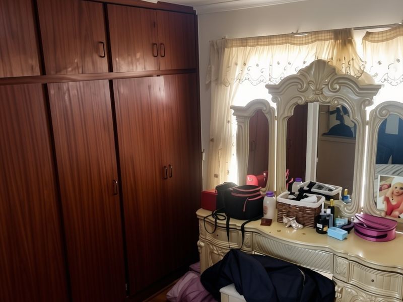A bedroom featuring extensive built-in wooden cabinetry and laminate flooring, offering ample storage space.