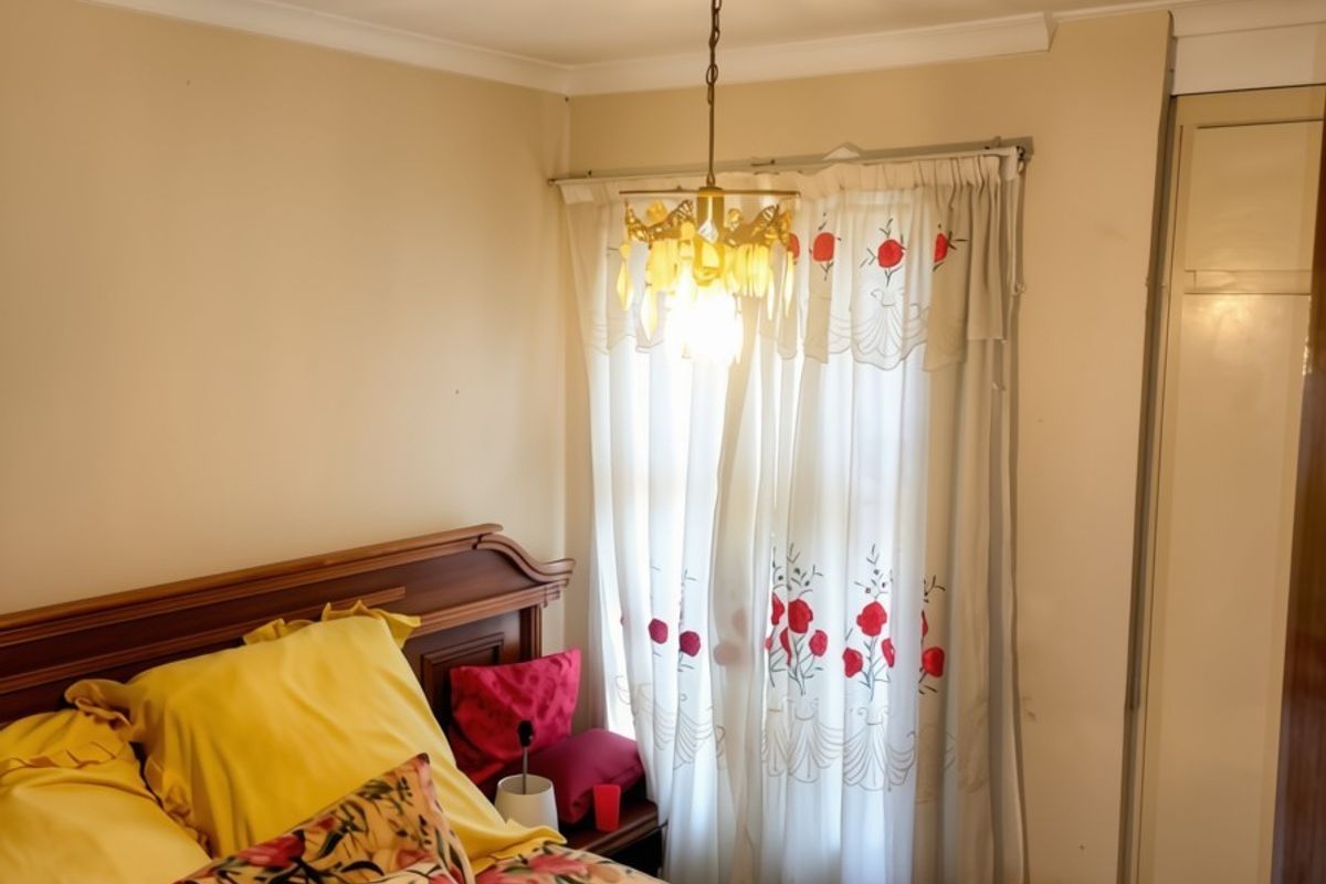 A cozy bedroom featuring a built-in wardrobe, decorative ceiling coving, and a central light fixture, offering a functional and comfortable sleeping space.