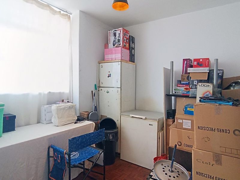 A utility or storage room featuring parquet flooring and a large window, currently used for storage.