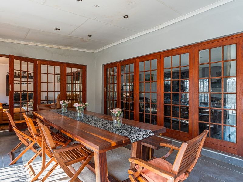 Covered patio area featuring tiled flooring and extensive wooden framed glass folding doors providing seamless access to the interior living spaces.
