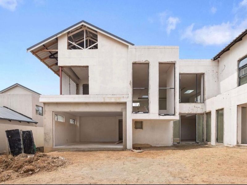 Rear view of a double-storey residential property currently under construction, featuring exposed structural elements and an unfinished exterior facade.