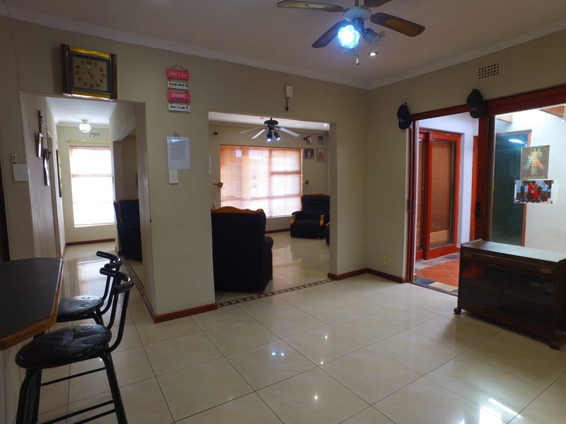 Open plan living area featuring tiled flooring, ceiling fans, and sliding glass doors providing access to the exterior.