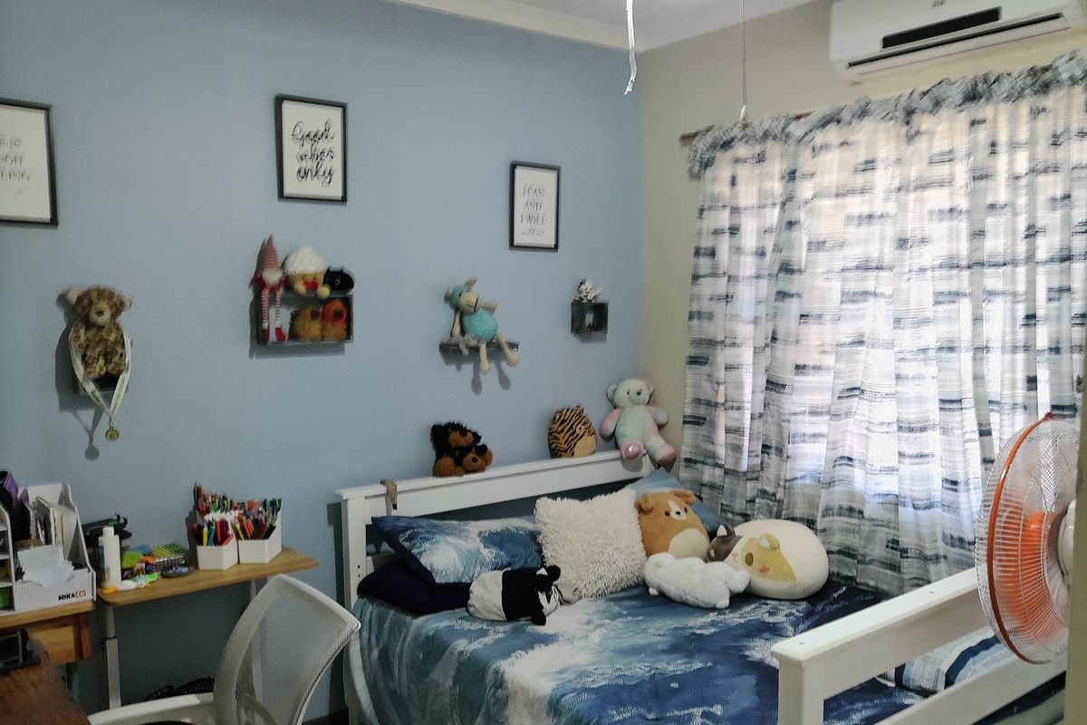 A bedroom featuring a split-system air conditioner and blue-painted walls, providing a functional space with standard residential finishes.