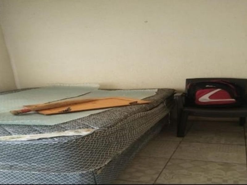 A bedroom space featuring tiled flooring and plain walls, currently requiring cosmetic updates and maintenance to improve its overall condition.