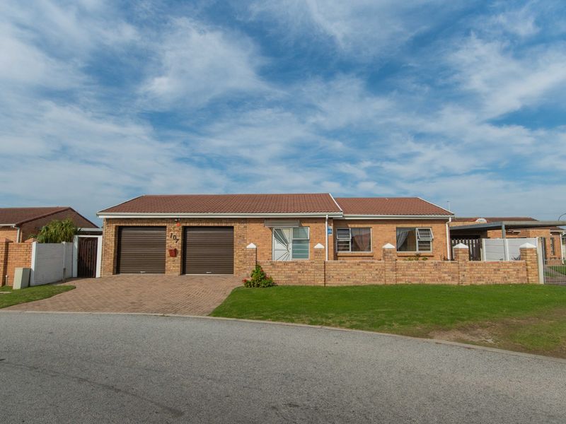Front elevation of a single-story brick house featuring a double garage, paved driveway, and a low-maintenance front garden.