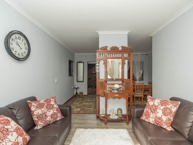 A living room area featuring tiled flooring and coved cornicing, providing a neutral base for interior design updates.