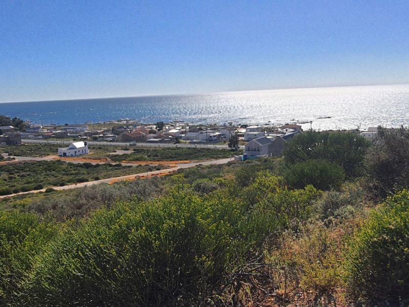 A scenic elevated view overlooking the coastal town and the ocean, showcasing the natural landscape and surrounding residential area.