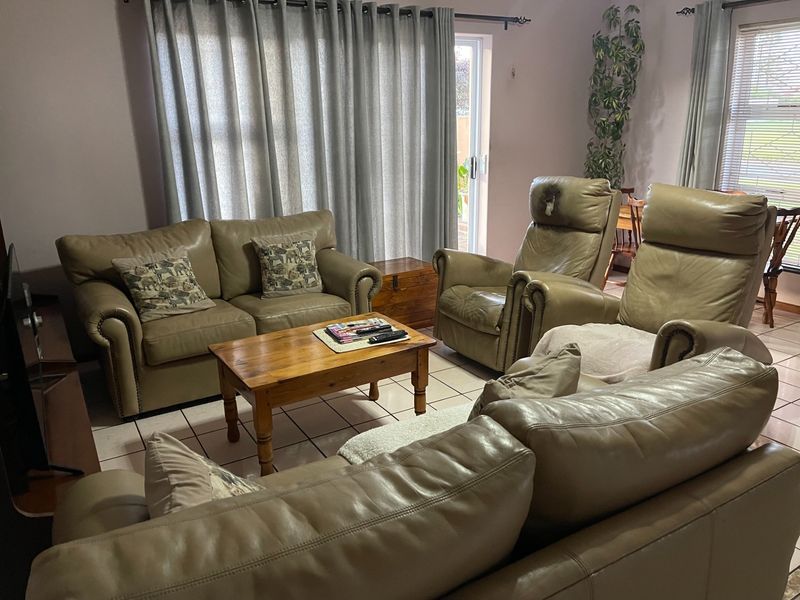 A comfortable living room featuring tiled flooring and a sliding glass door providing access to the outdoor area.