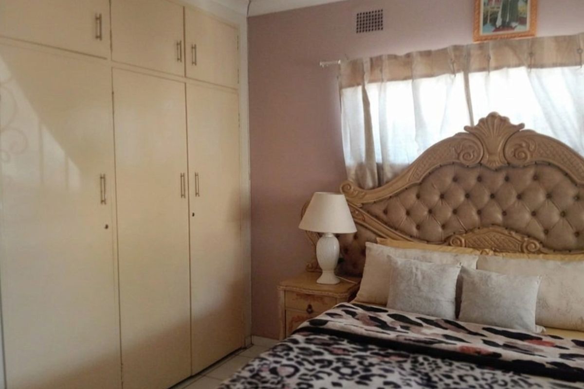 A bedroom featuring built-in cupboards and neutral wall finishes, providing functional storage space.