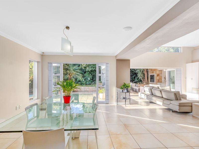 Spacious open-plan living and dining area featuring large sliding glass doors that provide seamless access to the outdoor patio and garden.