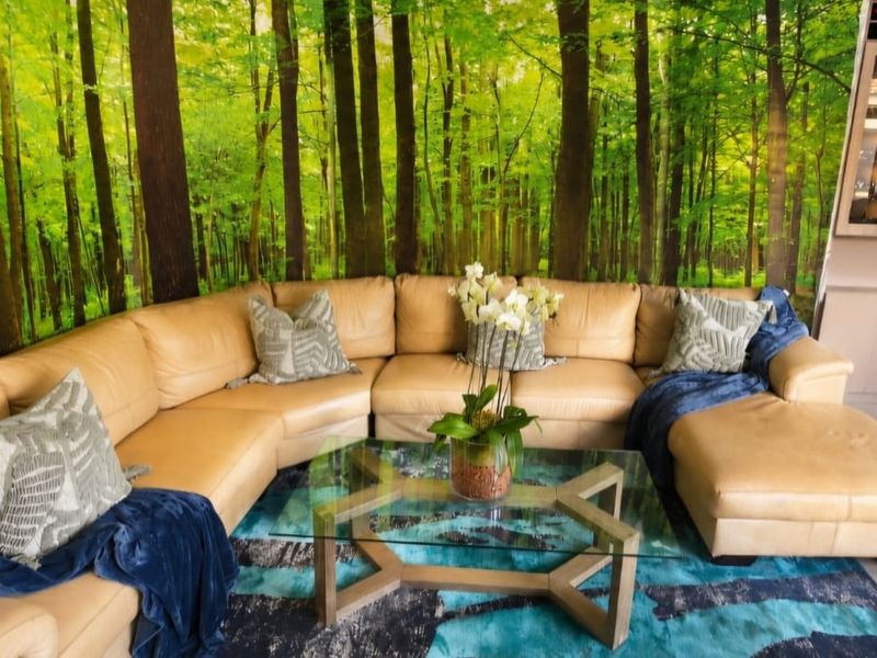 A living room featuring tiled flooring, built-in cabinetry, and a dedicated wine storage unit, accented by a forest-themed feature wall.