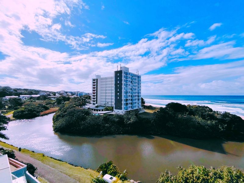Aerial view of the Santana apartment building situated on a scenic riverfront location adjacent to the coastline.