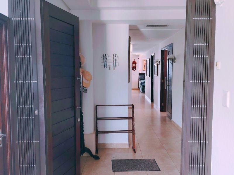 An entrance hallway featuring tiled flooring and a security gate, leading into the interior living spaces of the penthouse.