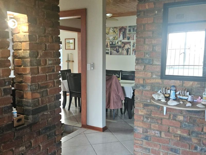 Living area featuring exposed brick walls, tiled flooring, and a timber ceiling, providing a rustic aesthetic with potential for modern updates.